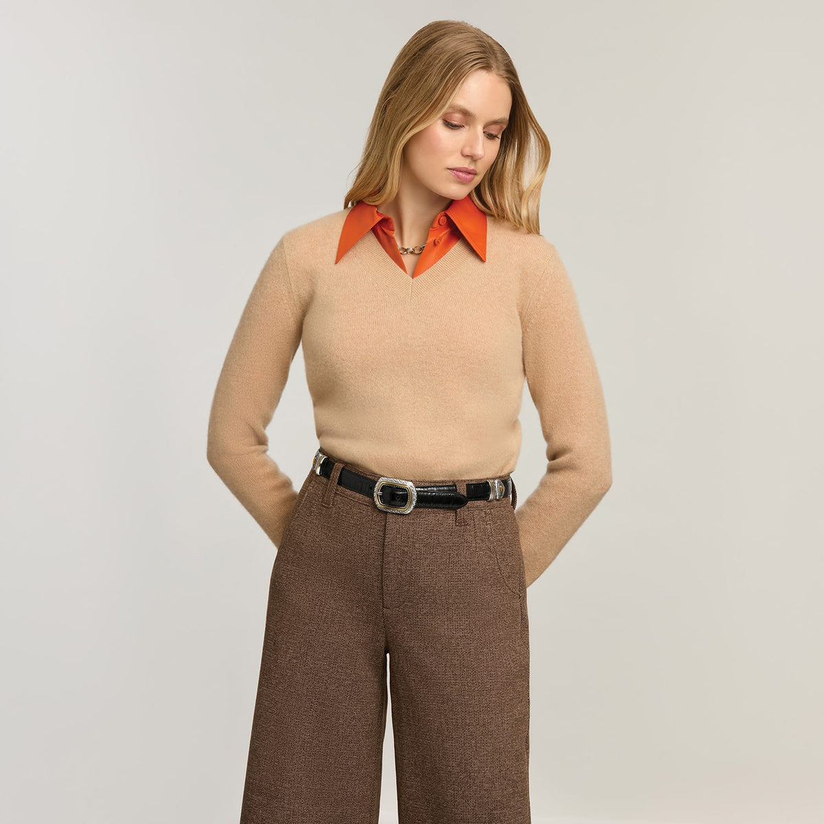 Model wearing a Brighton black leather belt with silver-tone engraved buckle and keeper detail at the waist