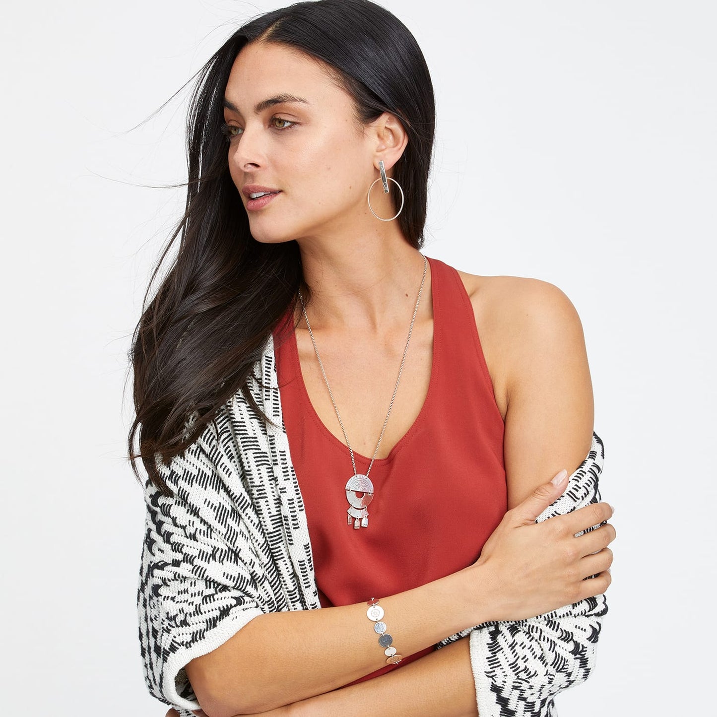 Model wearing a Brighton silver-plated pendant necklace with figural charm and coordinating hoop earrings and bracelet