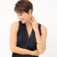 Model wearing a Brighton brushed gold hoop earring paired with stacked brushed gold bangle bracelets