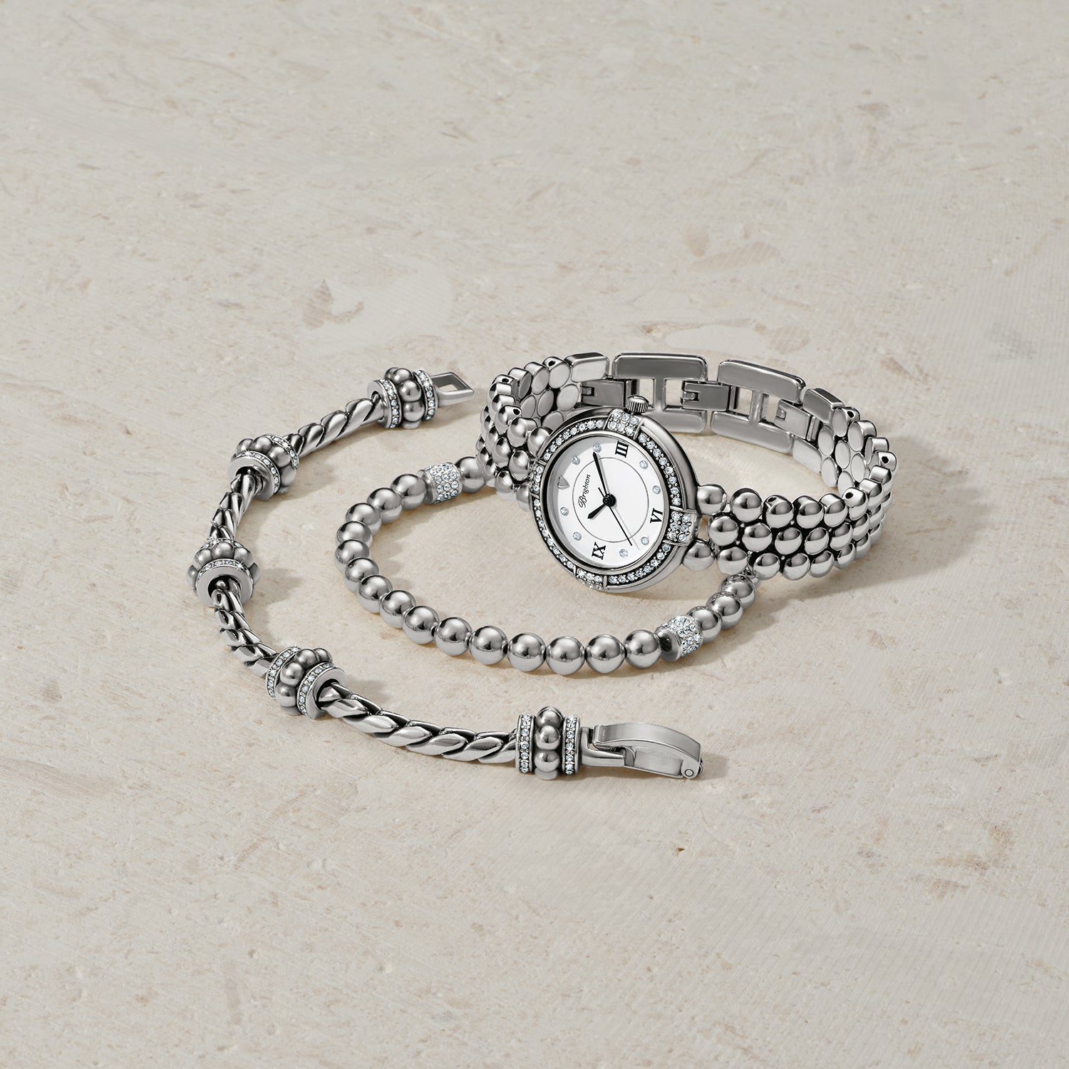 Brighton silver-plated watch with crystal-accented bezel styled with beaded bracelets featuring crystal stations on neutral background