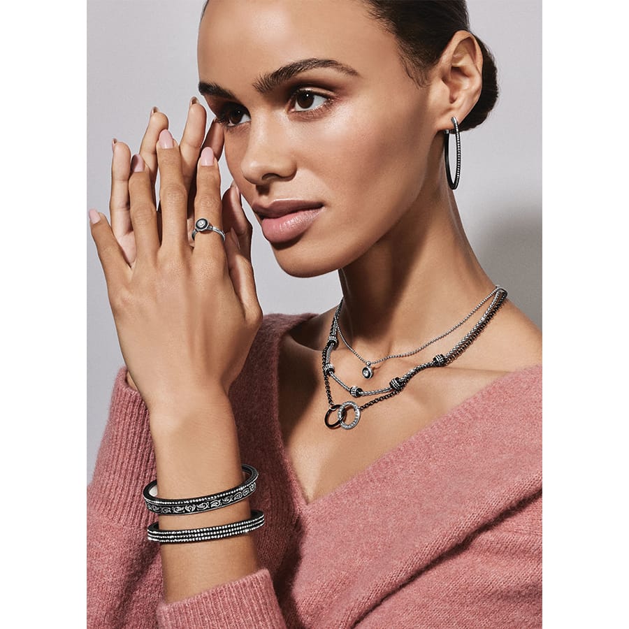 Model wearing Brighton black lacquer hoop earrings with crystal accents and coordinating Brighton accessories