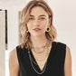 Model wearing layered Brighton two-tone necklaces with crystal accents paired with matching gold hoop earrings