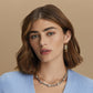 Model wearing Brighton gold hoop earrings paired with a two-tone layered necklace featuring crystal accents and twisted chain