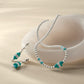 Brighton silver-plated beaded necklace and drop earrings with turquoise beads and crystal accents, styled with a ceramic dish