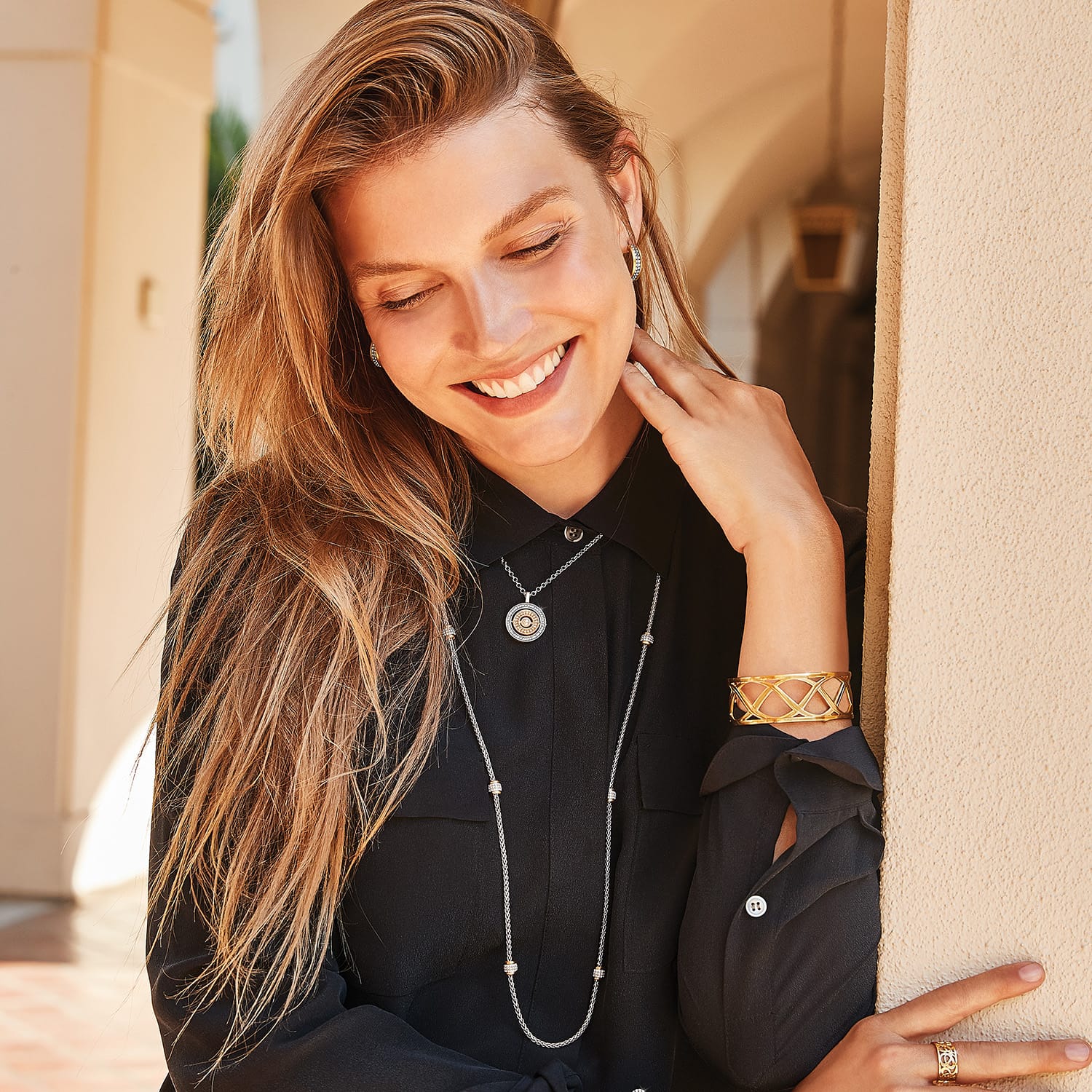 Model wearing a Brighton silver-tone crystal pendant necklace with coordinating Brighton accessories in two-tone finish