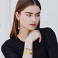 Model wearing Brighton gold drop earrings with crystal accents and coordinating Brighton two-tone bracelets with crystals