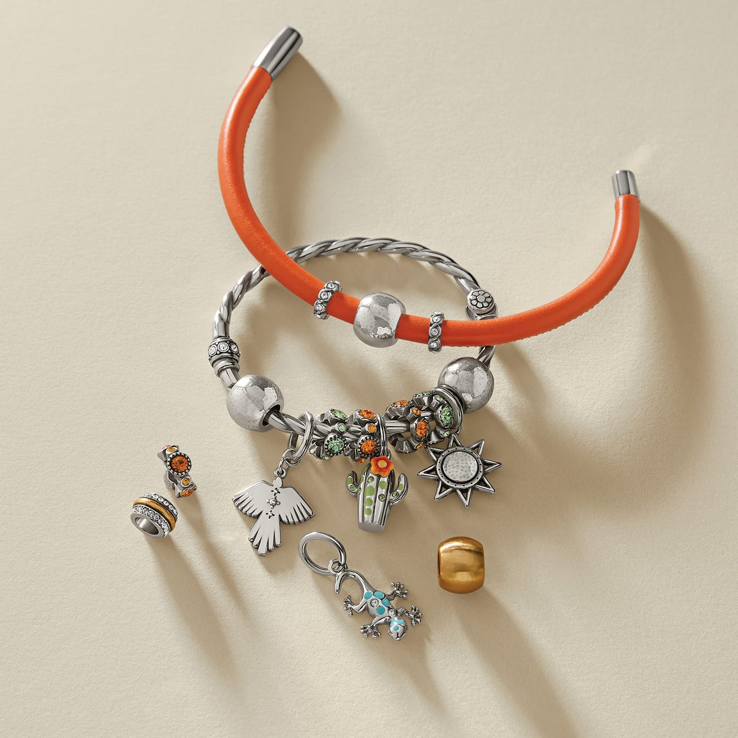Brighton charm bracelets styled with silver-plated charms and beads including cactus, sun, and gecko motifs