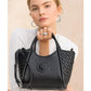 Brighton black handbag with woven leather sides, medallion accent, and adjustable crossbody strap held by model