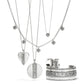 Brighton silver-plated jewelry set styled with layered heart and disc pendant necklaces, hoop earrings, and scroll-detailed cuff bracelet