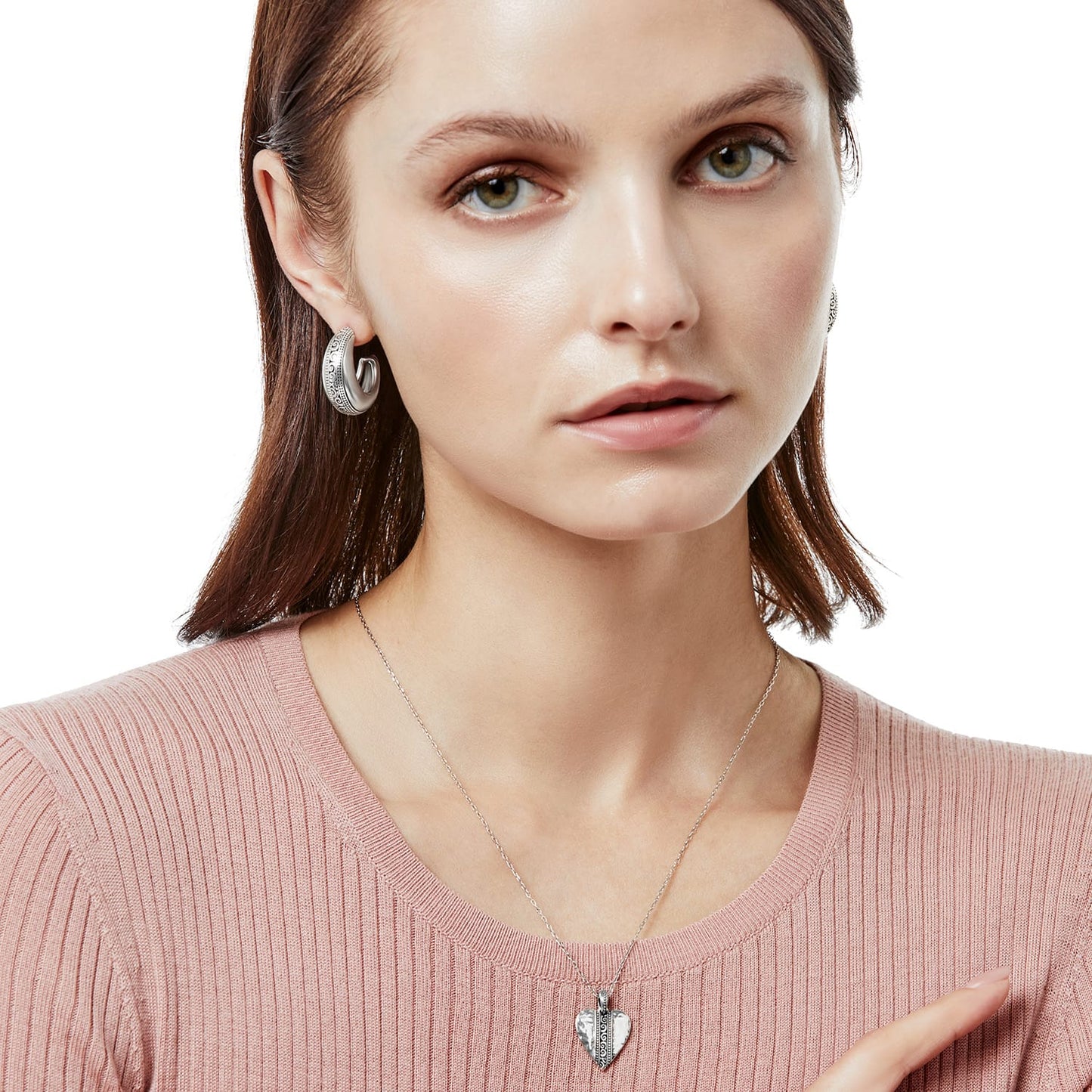 Model wearing Brighton silver-plated hoop earrings with engraved scroll detail paired with a silver-plated heart pendant necklace