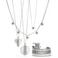 Brighton silver-plated jewelry set styled with layered scroll pendant necklaces, hoop earrings, and engraved cuff bracelet on white background