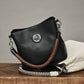 Brighton black leather handbag styled with a white leather bag and braided straps on a wooden surface