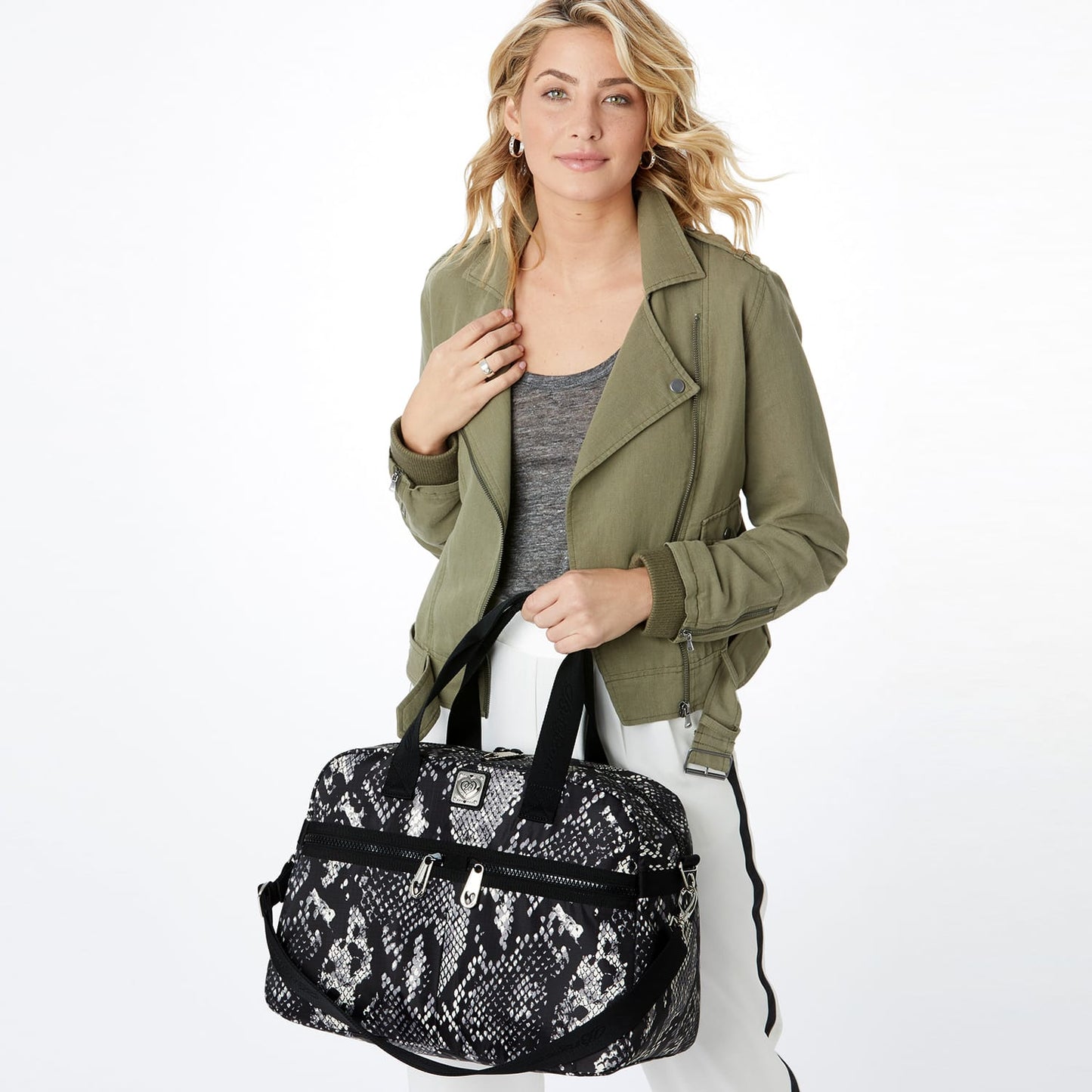 Model with a Brighton duffle handbag in black and white snakeskin print with black handles