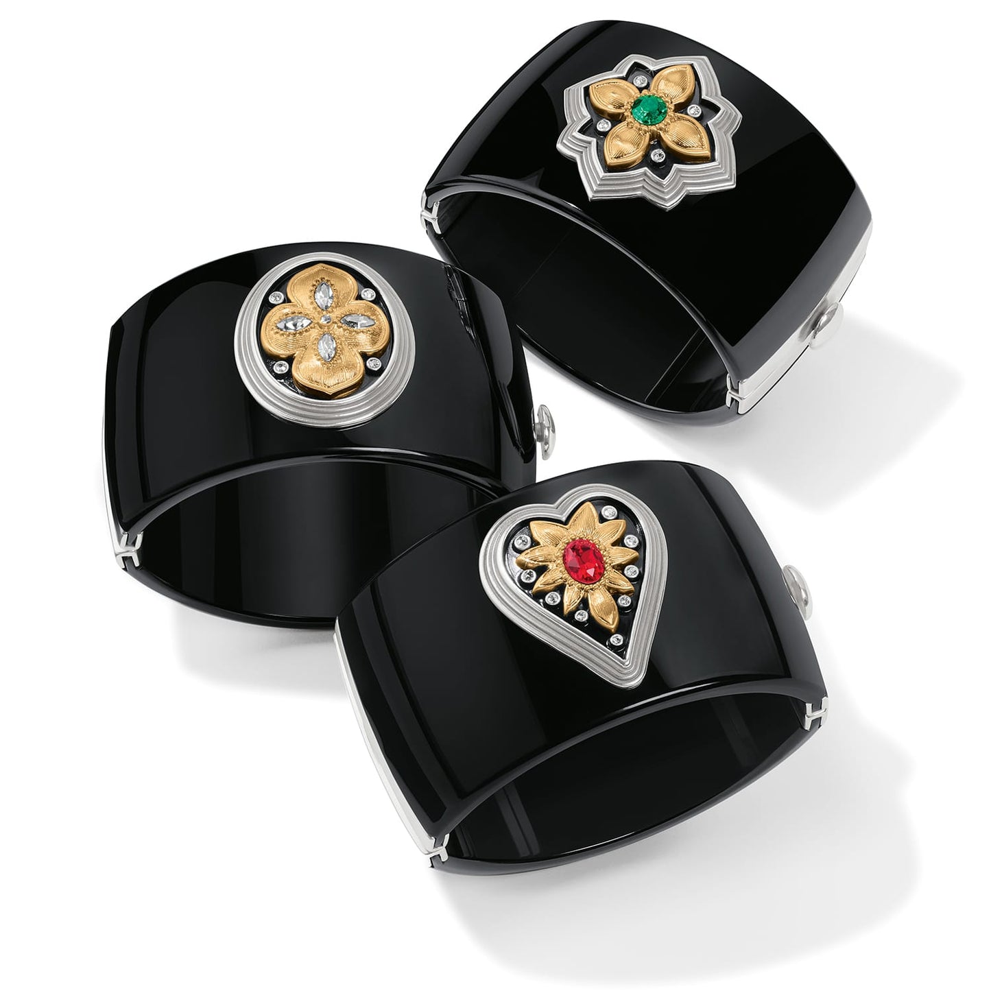 Brighton black hinged cuff bracelets with two-tone floral and heart medallions featuring crystal and colored stones on a white background