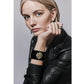 Model wearing a Brighton black cuff bracelet with two-tone floral medallion and green crystal center accent