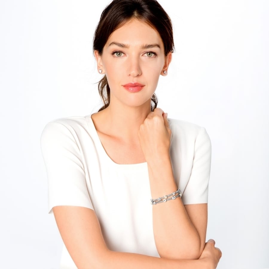 Model wearing a Brighton silver-plated beaded bracelet with crystal accents paired with matching stud earrings