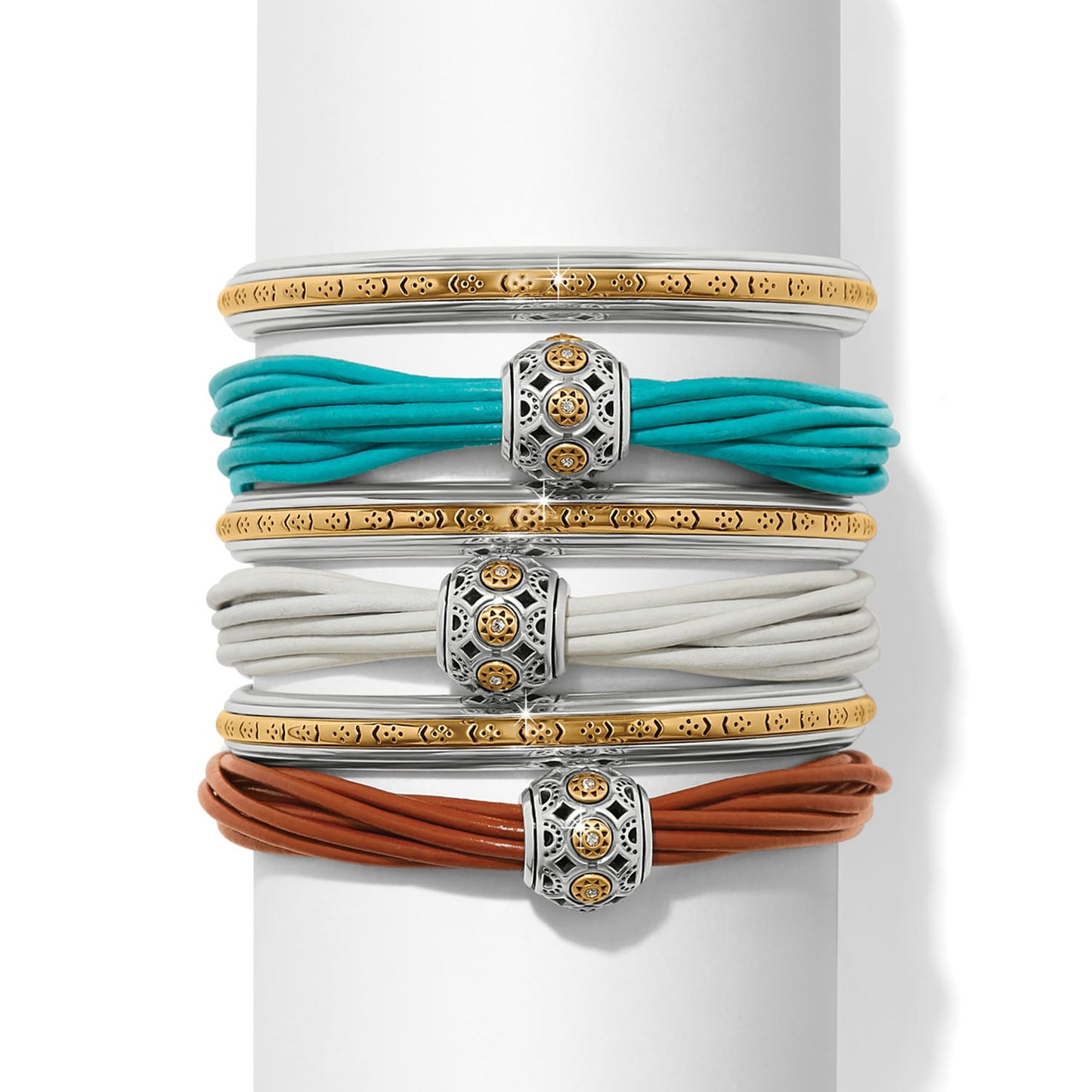 Brighton bracelet stack with two-tone bangles and turquoise, white, and brown leather cord designs on a white background