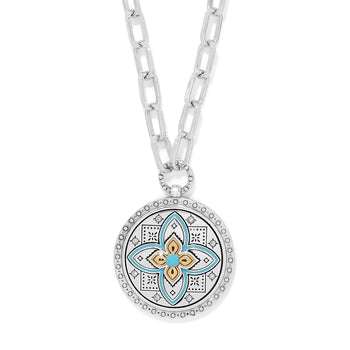 Brighton pendant necklace with two-tone medallion, turquoise enamel floral motif, crystals, and silver-tone chain on a white background