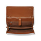 Brighton tan leather handbag shown open with interior zip pocket, suede lining, and tab closure on a white background