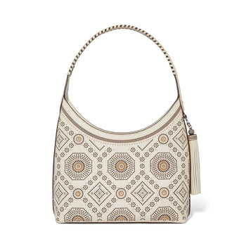 Brighton hobo handbag in cream leather with medallion perforated pattern, crystal studs, and tassel charm on a white background