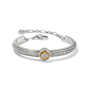 Brighton two-tone cuff bracelet with silver band, etched detailing, gold medallion center, and chain closure on a white background