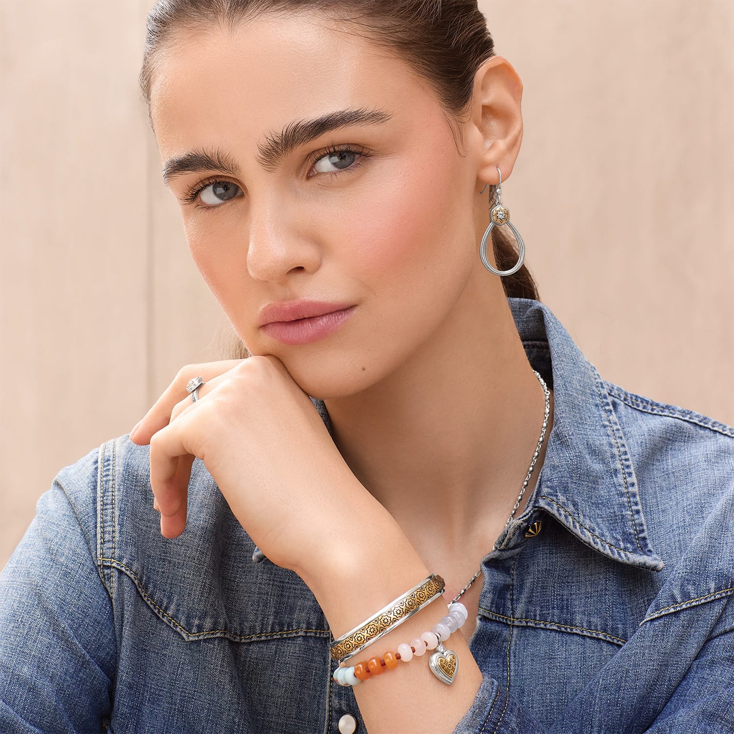Model wearing Brighton silver-plated drop earrings with crystal accents and coordinating Brighton accessories including bracelets and necklace