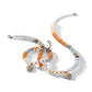 Brighton beaded necklace and bracelets with orange, blue, and cream stones featuring two-tone heart charms on a white background