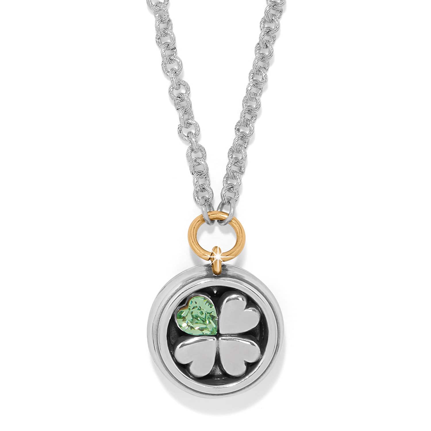 Brighton pendant necklace with silver four-leaf clover, green crystal heart, and gold-tone accent ring on a white background