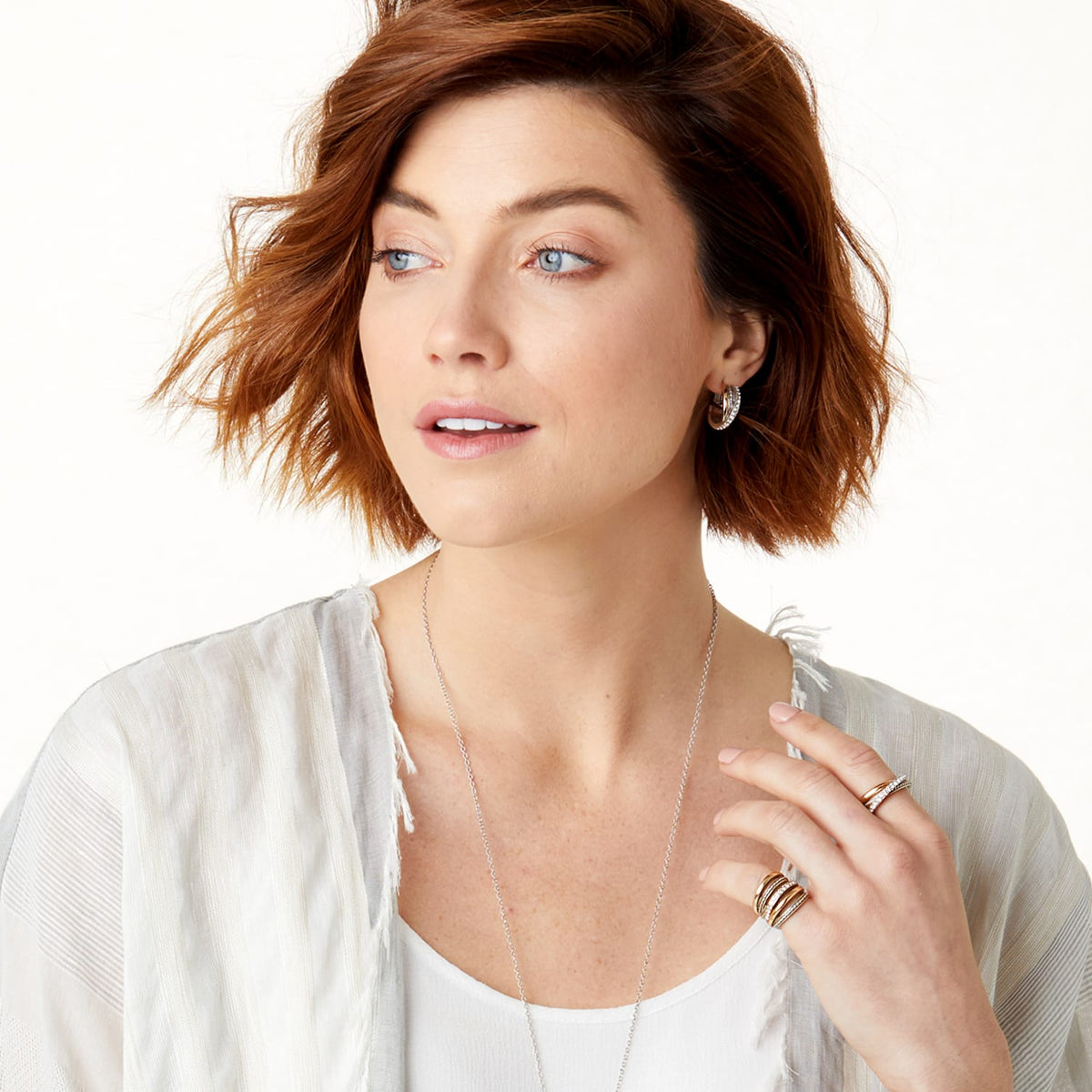 Model wearing Brighton two-tone hoop earrings with a long silver-tone chain necklace and coordinating Brighton rings