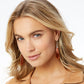 Model wearing Brighton drop earrings with elongated amber-toned stones and light rose gold and silver-plated accents