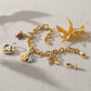 Brighton two-tone charm bracelet styled with maple leaf charms and dried autumn leaves on woven fabric