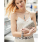 Model with a Brighton laser-cut cream leather clutch wallet and coordinating Brighton accessories including necklace and concho belt