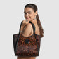 Model with a Brighton leopard print tote handbag featuring braided black leather straps and circular black medallion accent