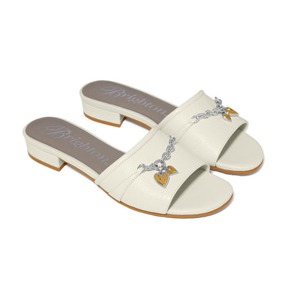 Brighton cream leather slide sandals with silver-tone chain and gold heart charm details on a white background