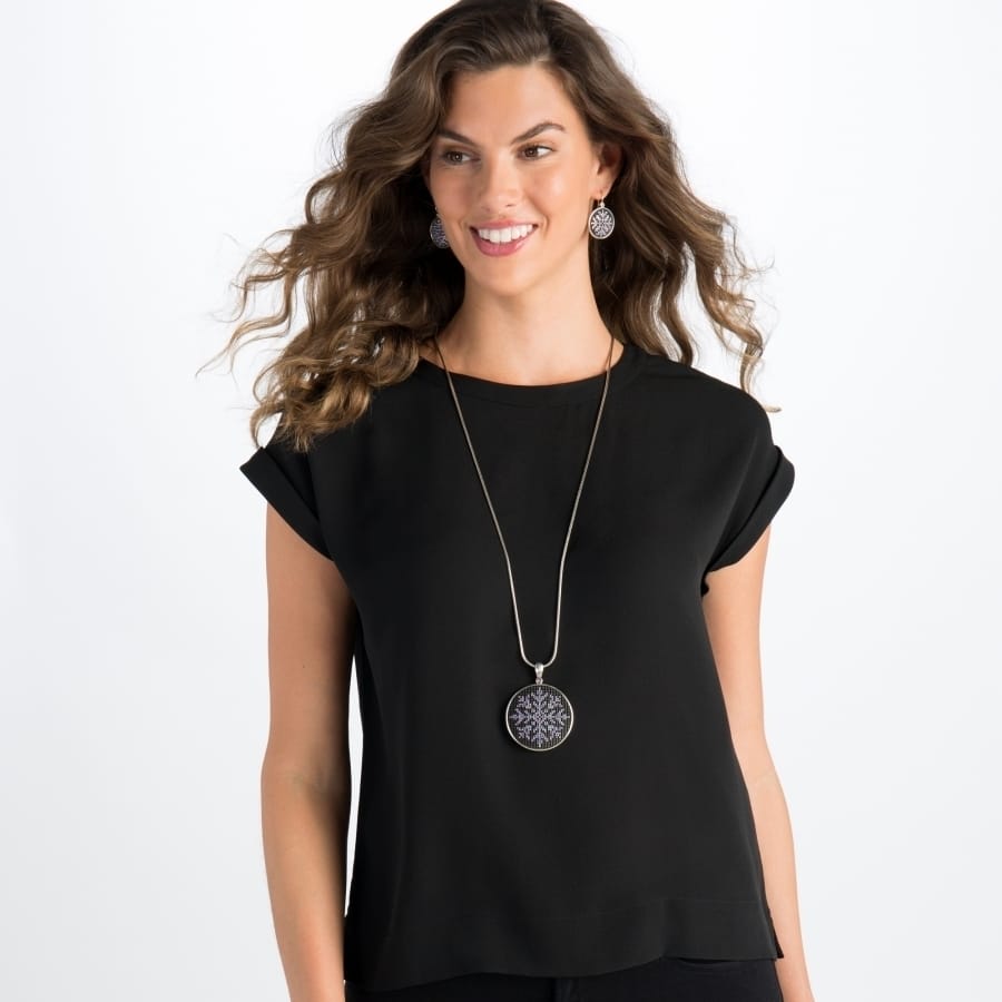 Model wearing a Brighton silver-plated pendant necklace with ornate medallion, paired with matching round drop earrings
