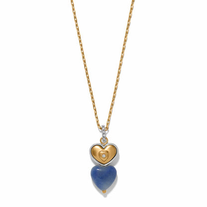 Brighton pendant necklace with two-tone heart charm, blue stone heart drop, and crystal accents on a white background