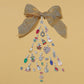 Brighton silver-plated and gold-plated charms styled with a gold ribbon bow arranged in a Christmas tree shape