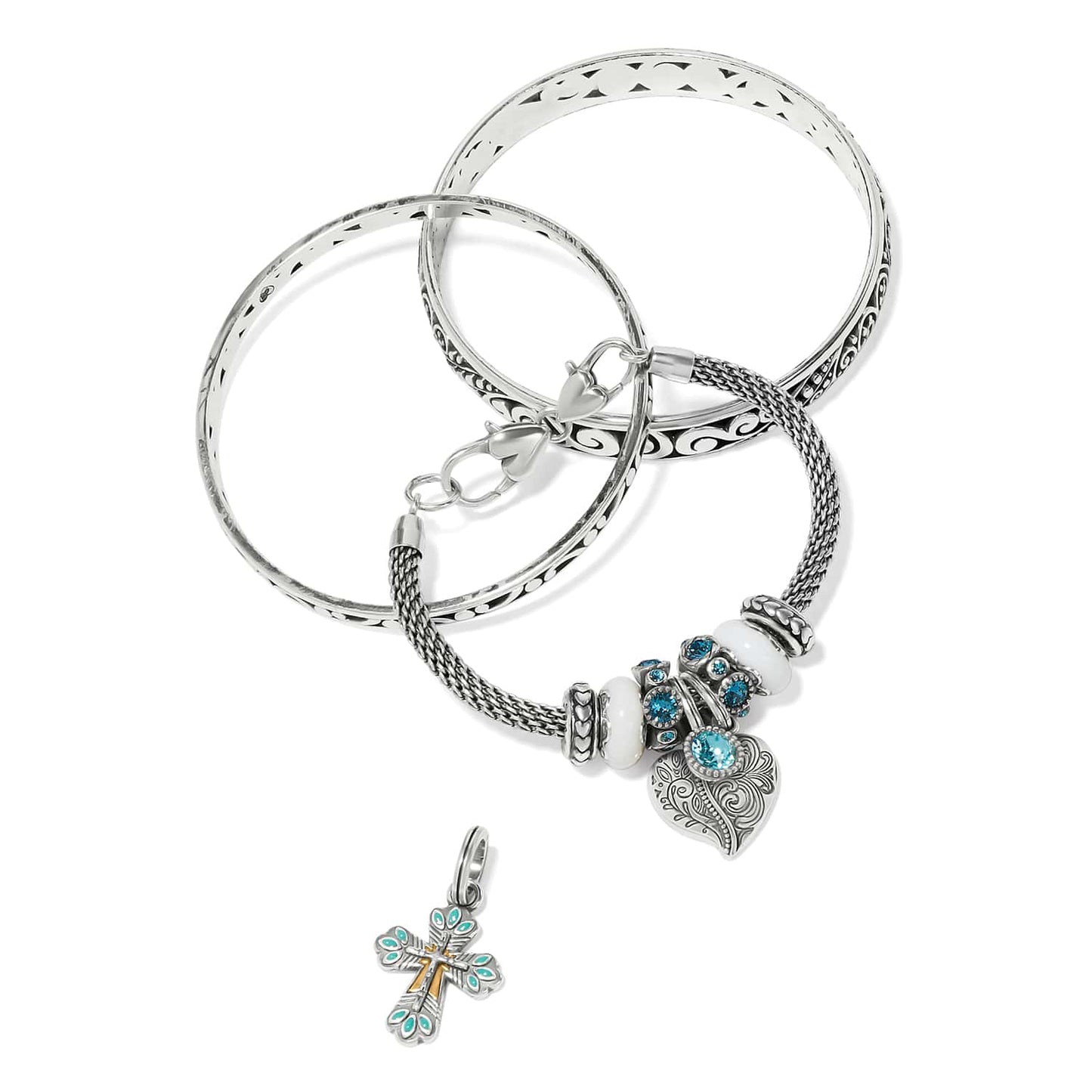 Brighton silver-plated bangle bracelets styled with a blue crystal charm bead set and cross charm on white