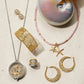 Brighton jewelry collection styled with a nautilus shell and pink beaded necklace on a neutral background