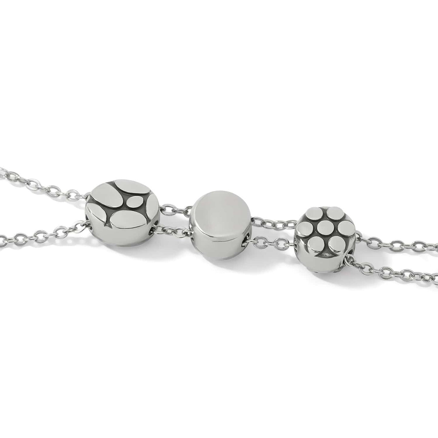 Close-up of Brighton bracelet with three silver-plated round beads featuring dot and abstract patterns on delicate chains