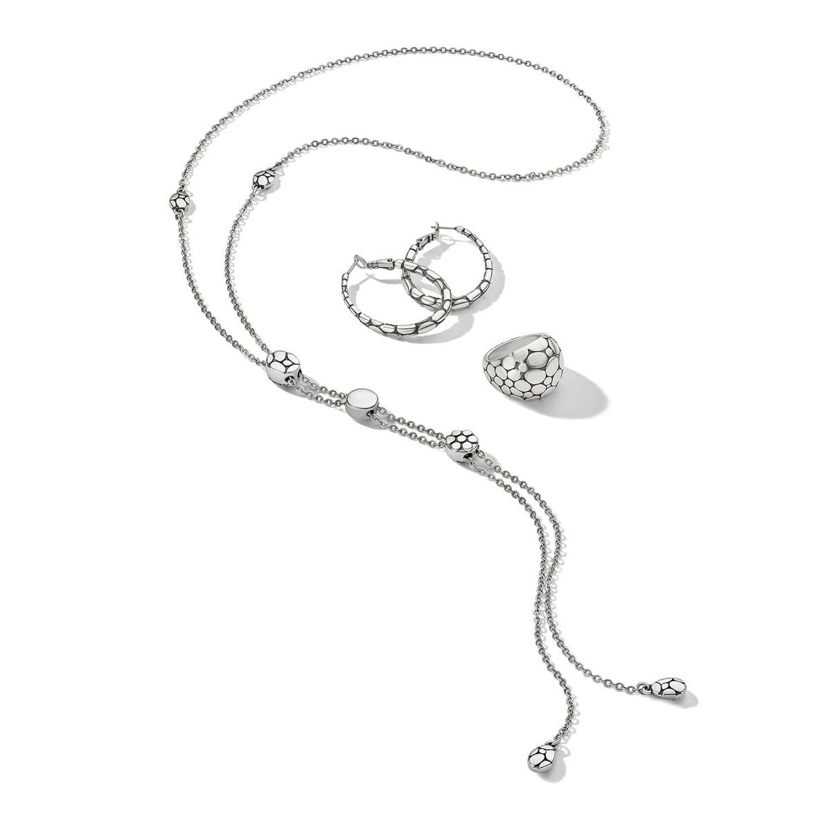 Brighton silver-plated jewelry set styled with lariat necklace, hoop earrings, and dome ring on a white background