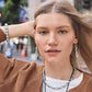 Model wearing Brighton silver-plated drop earrings with twisted loop design and coordinating Brighton necklace and bracelet