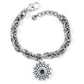Brighton charm bracelet with silver-plated chain links and round medallion charm featuring blue crystal on a white background