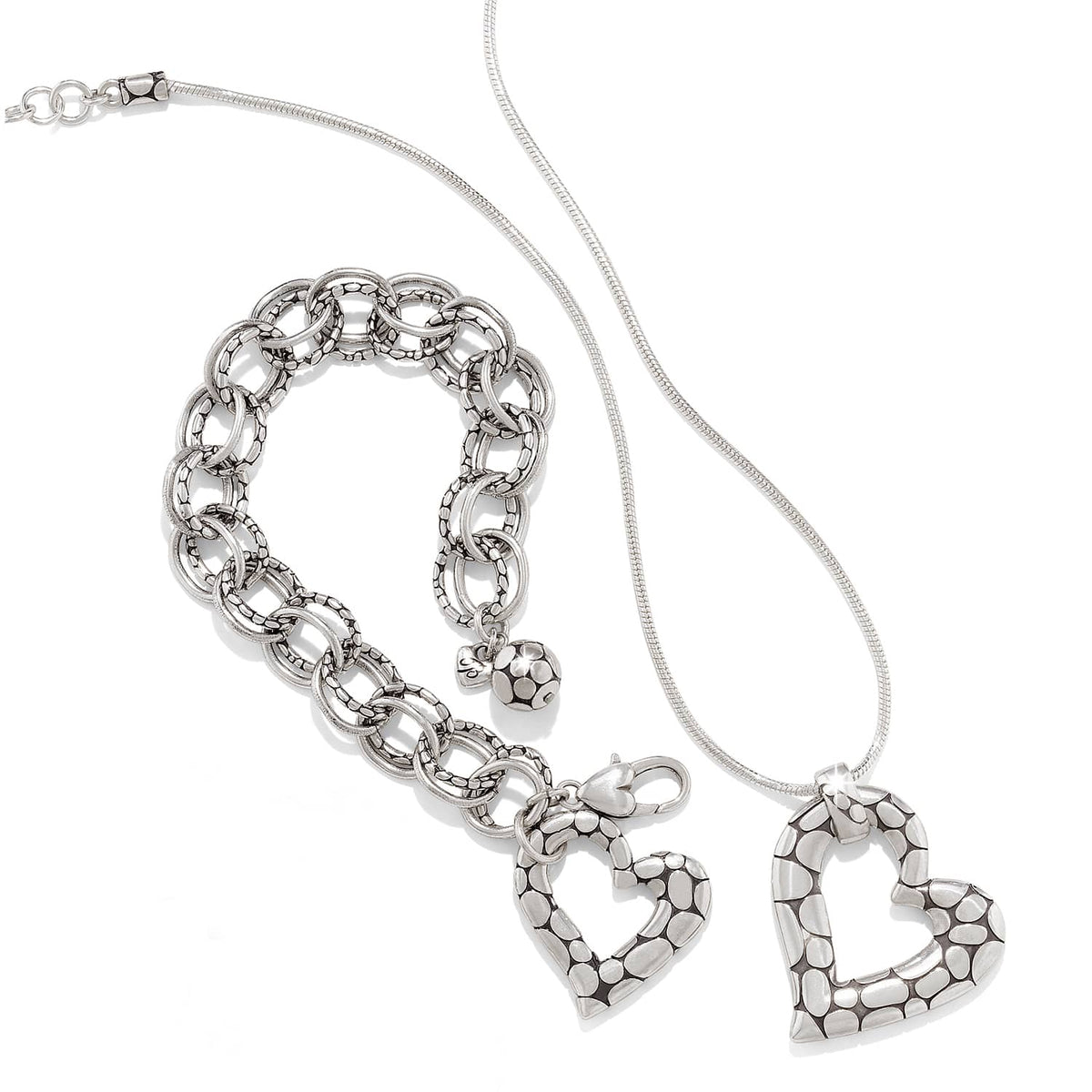 Brighton silver-plated heart pendant necklace styled with matching link bracelet featuring pebbled texture on white background