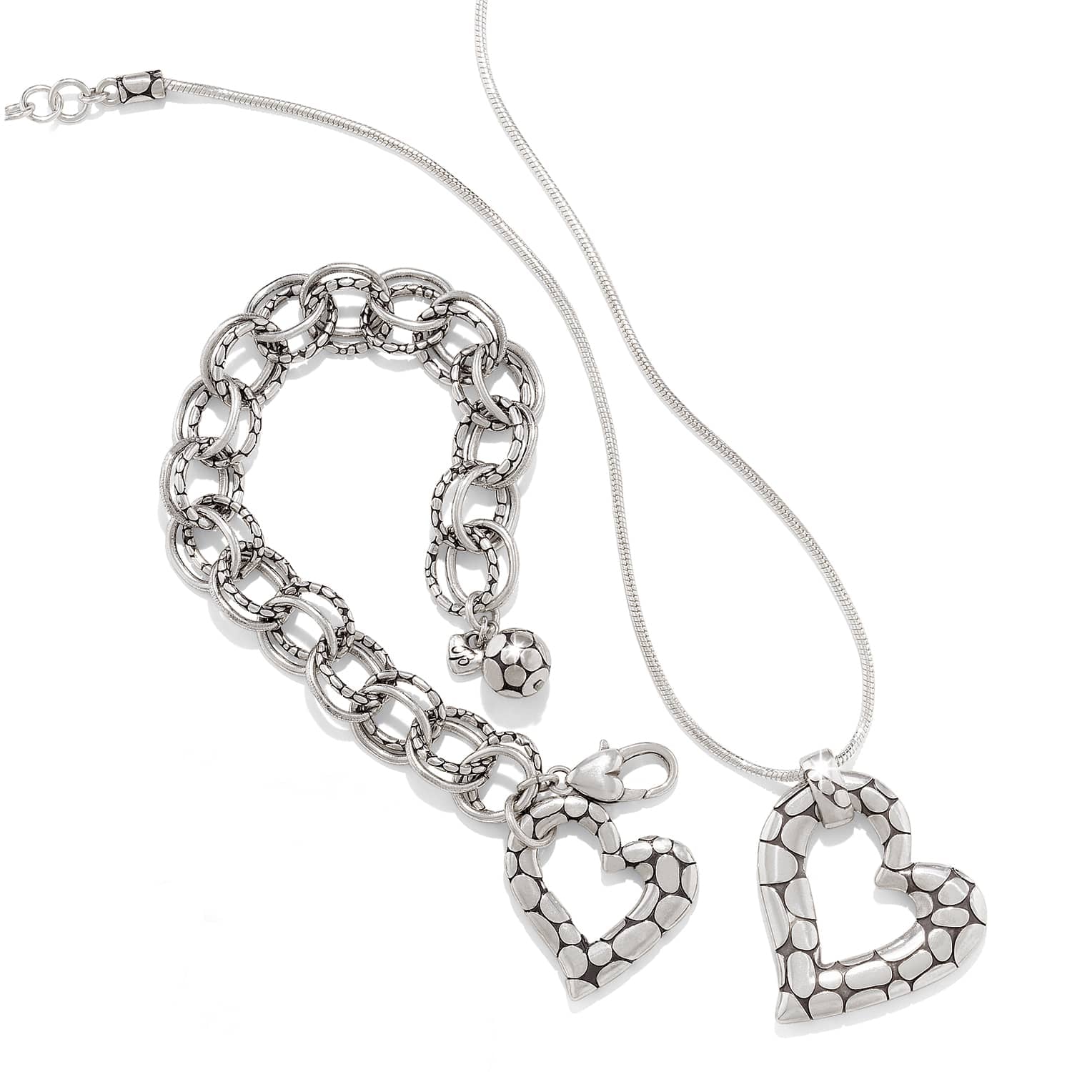 Brighton silver-plated heart pendant necklace styled with a matching link bracelet featuring pebbled texture on white