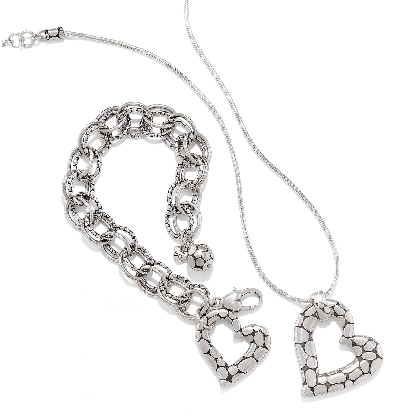 Brighton silver-plated heart pendant necklace styled with a matching link bracelet featuring pebbled texture on white
