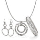 Brighton jewelry set with silver-plated hoop earrings, circular pendant necklace, and textured pebble bangle on a white background