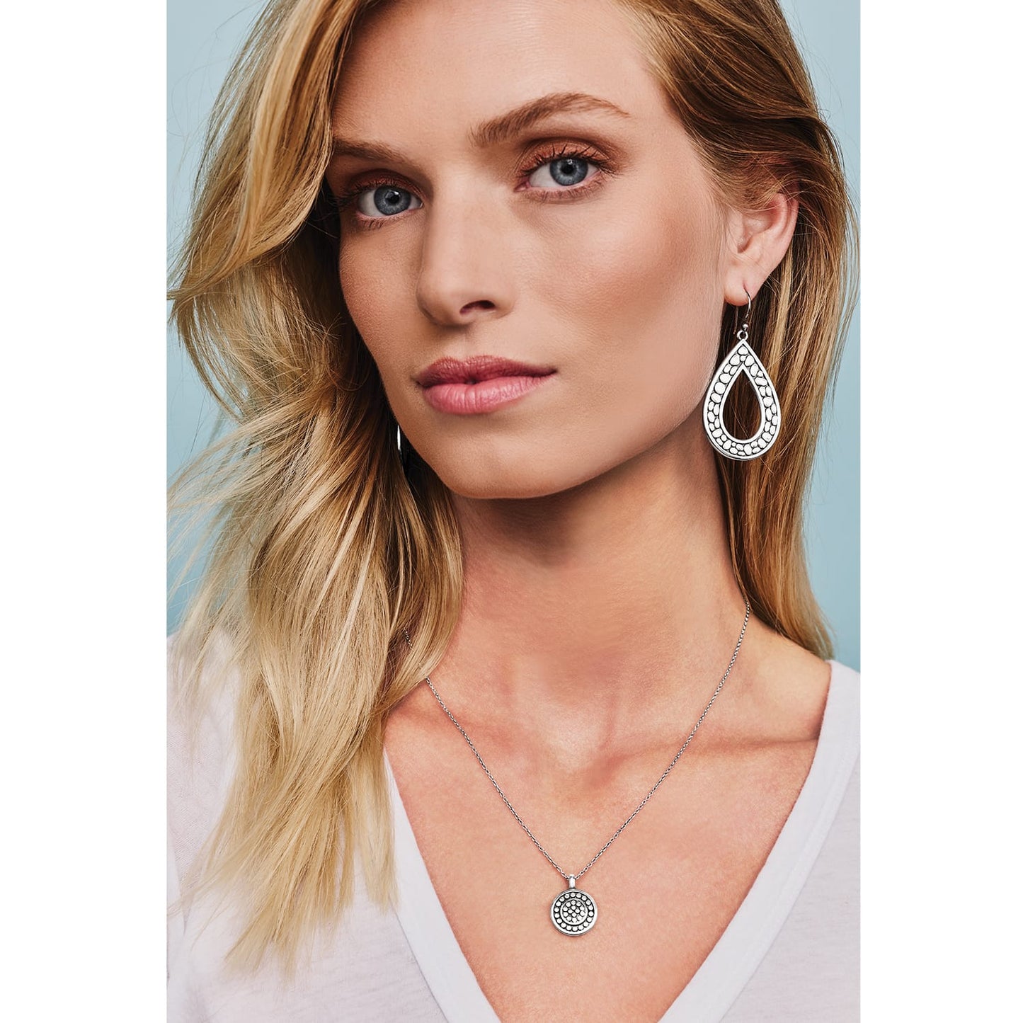 Model wearing Brighton silver-plated teardrop earrings with dotted texture paired with a matching round pendant necklace