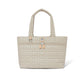 Brighton tote handbag in beige quilted heart pattern with dual handles, front zip pocket, and leather pulls on a white background