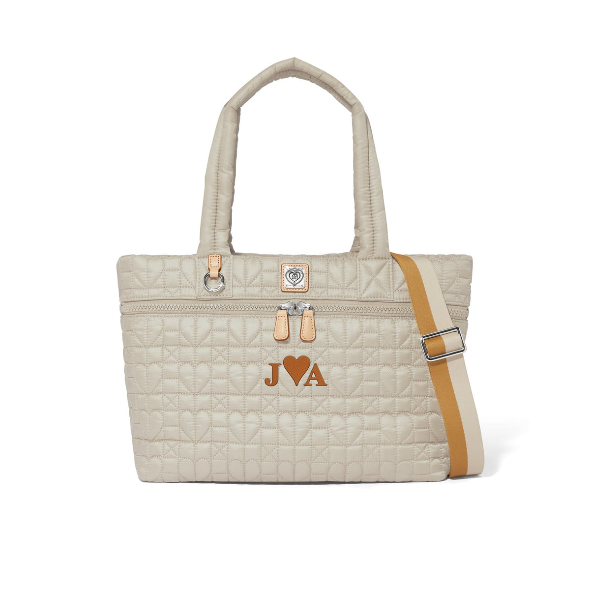 Brighton quilted handbag in cream with heart pattern, J heart A monogram, and tan crossbody strap on a white background